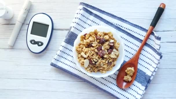 Средства для измерения диабета и здоровые хлопья на завтрак в миске на столе — стоковое видео