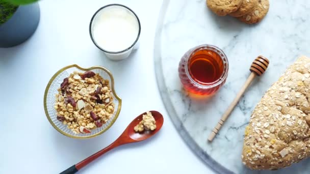 Desayuno de cereales en tazón, pan y miel sobre fondo blanco — Vídeos de Stock