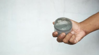 Beyaz arkaplan üzerinde kabarcık kil maske el ele tutun 