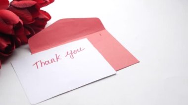 Beyaz arka planda lale çiçeğiyle yapışkan notta teşekkür ederim. 