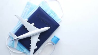 Masada koruyucu maske, uçak ve mavi renkli pasaport 