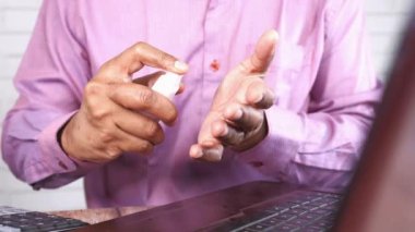 Delikanlının elini dezenfektan spreyiyle kapat..