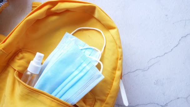 Studentská školní taška s dezinfekčním prostředkem, obličejová maska. — Stock video