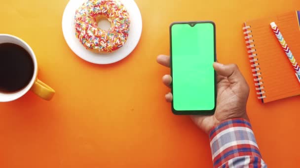 Horní pohled na člověka rukou pomocí chytrého telefonu na oranžovém pozadí — Stock video