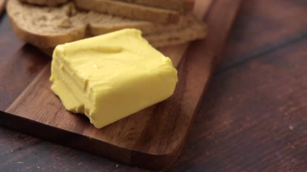 Scheibe Butter und Vollkornbrot auf Schneidebrett — Stockvideo