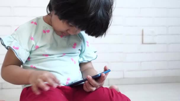 Criança menina assistindo desenhos animados no telefone inteligente — Vídeo de Stock