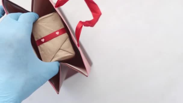 Mão em luvas de látex wapping uma caixa de presente com tecido — Vídeo de Stock