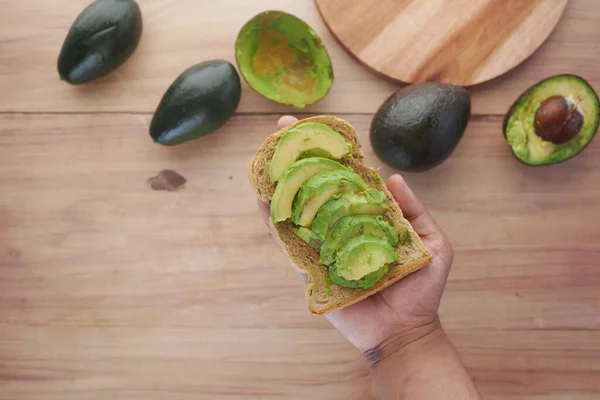 Mangiare pane marrone con fetta di avocado vista dall'alto — Foto Stock