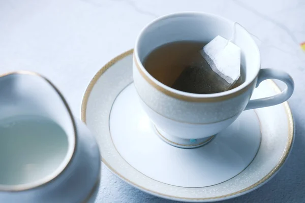 Té verde con bolsa de té sobre fondo de azulejos — Foto de Stock