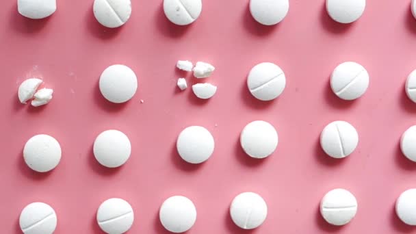 Pílulas médicas de cor branca derramando no rosa — Vídeo de Stock