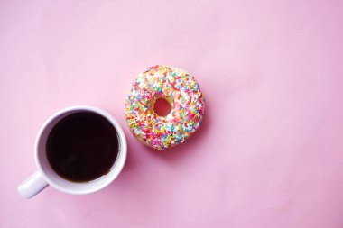 Renkli çöreklerin ve pembe kahve fincanının üst görüntüsü. 