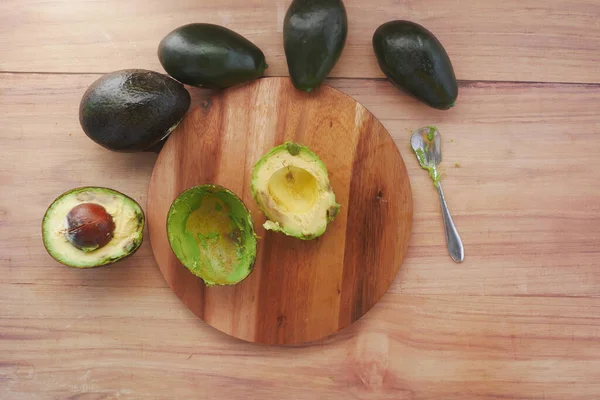 Vista superior de la rebanada de aguacate en la tabla de cortar en la mesa — Foto de Stock