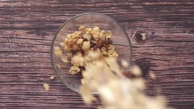  Tahta arka planda kaseye düşmüş mısır gevreği. 