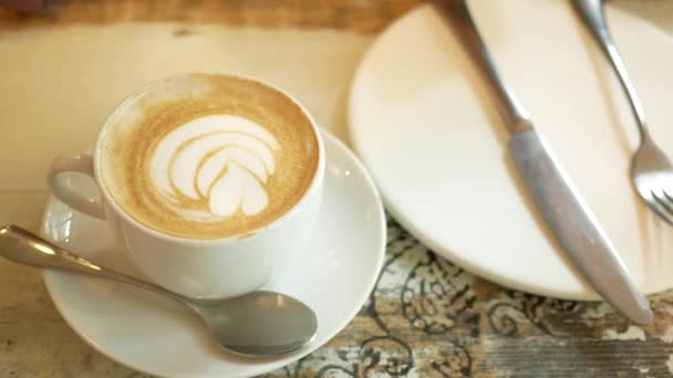 Una taza de café tardío con diseño de forma de flor en la parte superior en la cafetería — Vídeo de stock