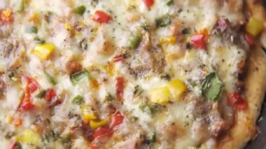 Tahta masadaki bir tabakta peynirli pizza..