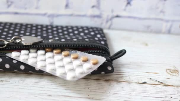 Antikoncepční pilulky a malý sáček na dřevěném pozadí, — Stock video