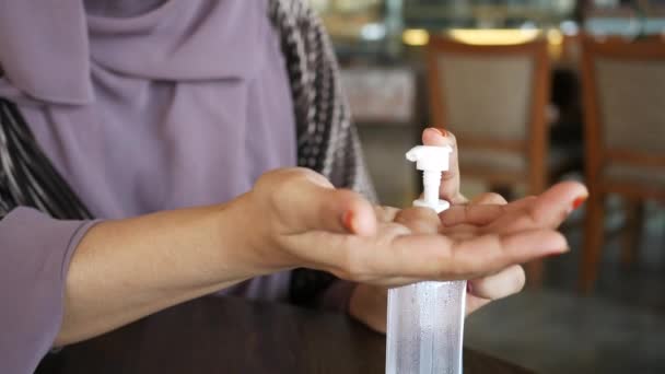 Mulheres jovens usando higienizador de mão no café — Vídeo de Stock