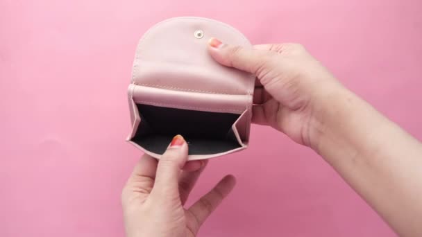 Жінки руки відкривають порожній гаманець на рожевому фоні — стокове відео
