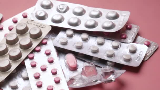 Close-up van pillen van blisterverpakking op roze achtergrond — Stockvideo