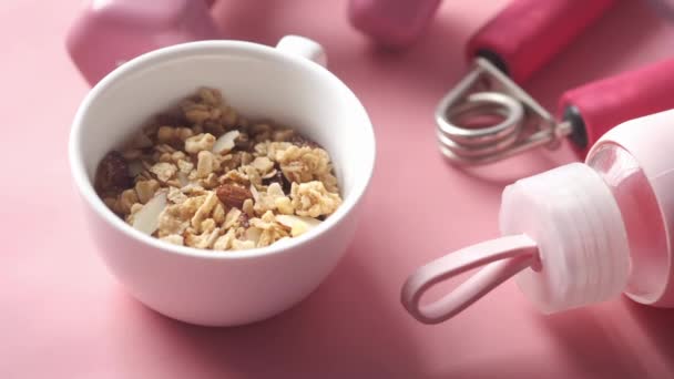 Céréales petit déjeuner dans un bol avec haltère sur fond rose — Video