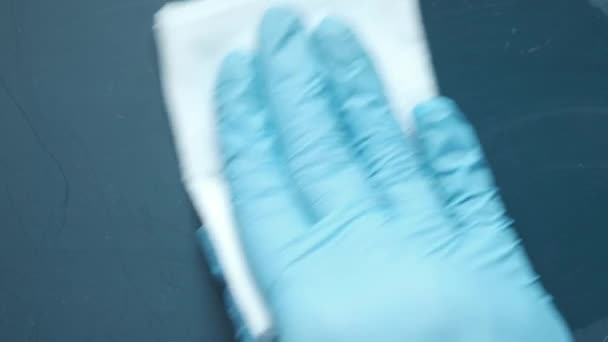 Hand in blaue Gummihandschuhe Reinigungstisch mit Tuch — Stockvideo