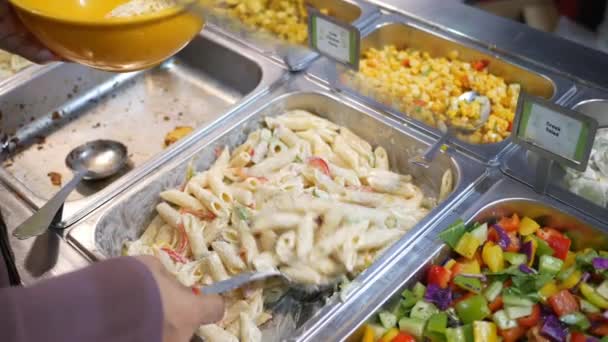 Usar cuchara para recoger pasta en un tazón en la cafetería de autoservicio — Vídeo de stock