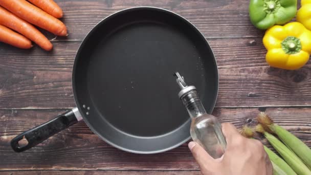 Plantaardige olie in de koekenpan gieten. — Stockvideo