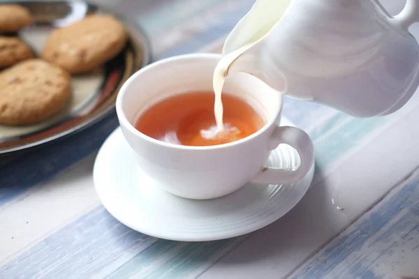 Primer plano de verter leche en una taza de té — Foto de Stock
