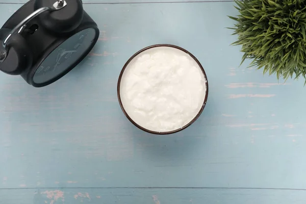 Närbild av färsk yoghurt i en skål på trä bakgrund — Stockfoto