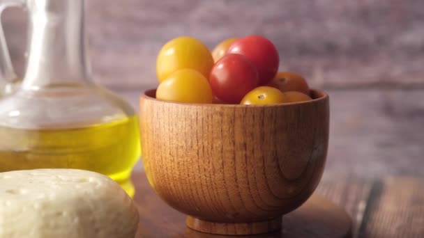 Colorido tomate cereza, queso y aceite de oliva en la mesa — Vídeos de Stock