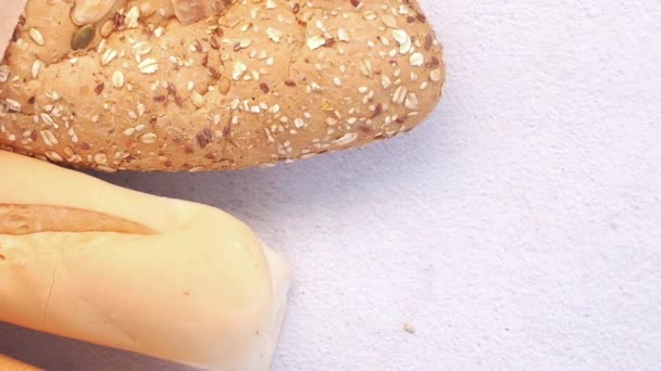 Recogiendo pan integral de grano marrón horneado en la mesa — Vídeos de Stock