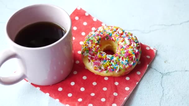 Rosquillas de colores y taza de café en la mesa — Vídeos de Stock