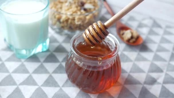 Frischer Honig mit Löffel, Milch auf dem Tisch — Stockvideo