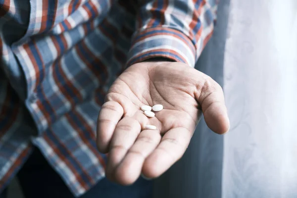 Primer plano de color blanco píldora médica en la palma de la mano — Foto de Stock