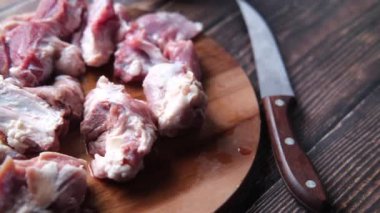 Tahtada çiğ kırmızı et ve taze sebze var. .