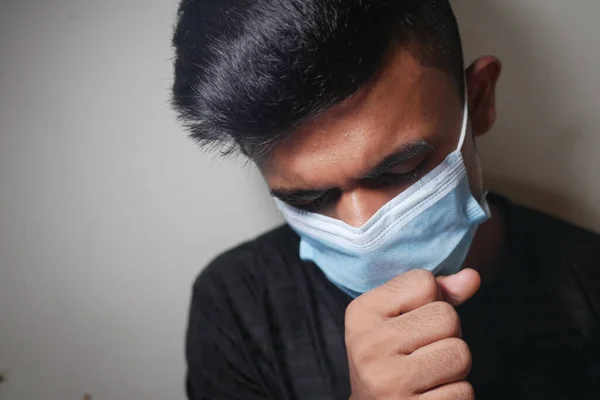 Fiatal beteg ember köhög, és tüsszent a fehér fal — Stock Fotó