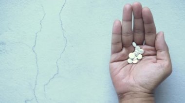 Bitkisel ilaçlar ve avuç içinde tıbbi haplar. 