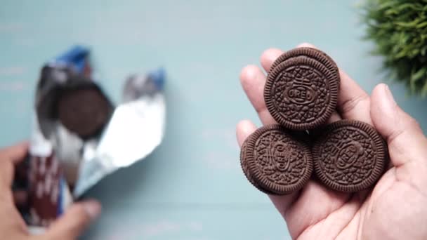 Primer plano de oreo galletas dulces en la mano — Vídeos de Stock