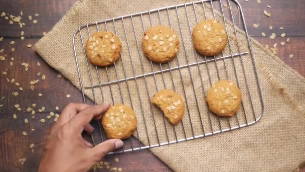 Χέρι πάρει ολόκληρο το γεύμα cookies σε ξύλινο φόντο — Αρχείο Βίντεο
