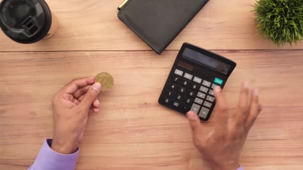 Dhaka bangladesz 23 maja 2021, posiadający złote bitcoiny i używający kalkulatora — Wideo stockowe