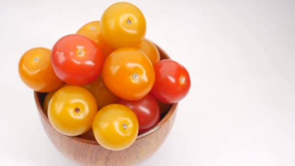 Tomate cereza de color rojo y amarillo en un tazón sobre fondo blanco — Vídeos de Stock