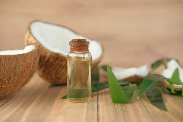 Rebanada de coco fresco y botella de aceite en una mesa — Foto de Stock