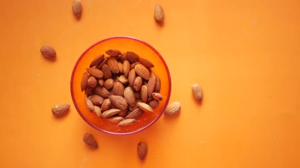 Vue du dessus des amandes dans un bol sur fond orange — Video