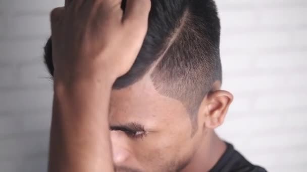 Vista lateral do homem styling cabelo com pente no fundo preto, — Vídeo de Stock