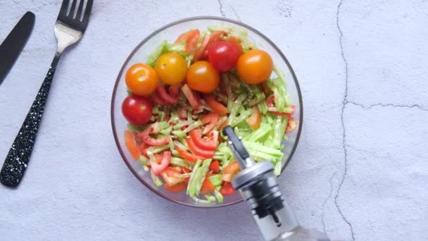 Menaruh minyak zaitun dalam sayuran segar salad mangkuk di atas meja, — Stok Video