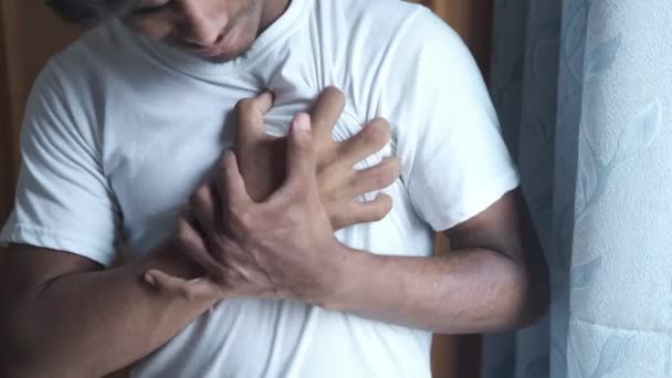 Young man suffering pain in heart and holding chest with hand — Stock Video