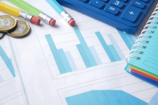 Pénzügyi grafikon, számológép és jegyzettömb az asztalon — Stock Fotó