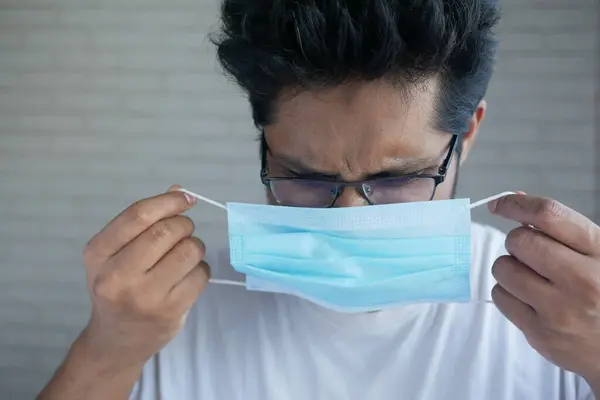 Genç Asyalı adam cerrahi yüz maskesi takıyor. — Stok fotoğraf