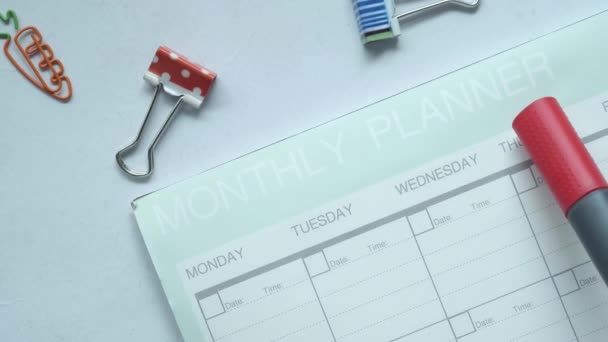 Wekelijkse planner en stationair op tafel — Stockvideo