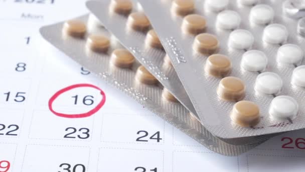 Tabletki antykoncepcyjne, kalendarz i notatnik na stole — Wideo stockowe